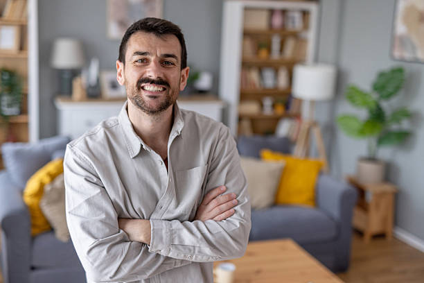 istock Bright and cheerful man standing with arms crossed 2242471803