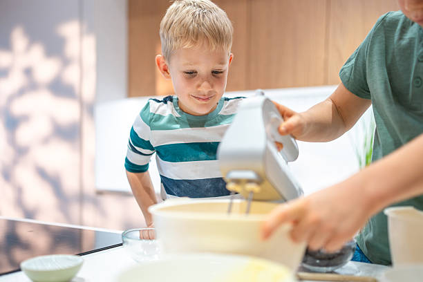 istock Caucasian Brothers Joyfully Mixing Cookie Dough 2242471868