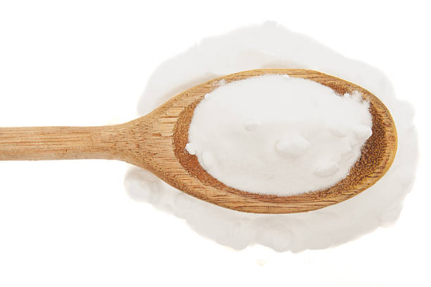 istock Close-up of baking soda in rustic wooden spoon on white background 2242473986