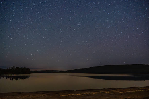 istock Clear starry sky over tranquil lake creating peaceful nighttime landscape. 2242482623