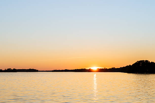 istock Sunset lake scene with gentle ripples and fading evening light. 2242482711