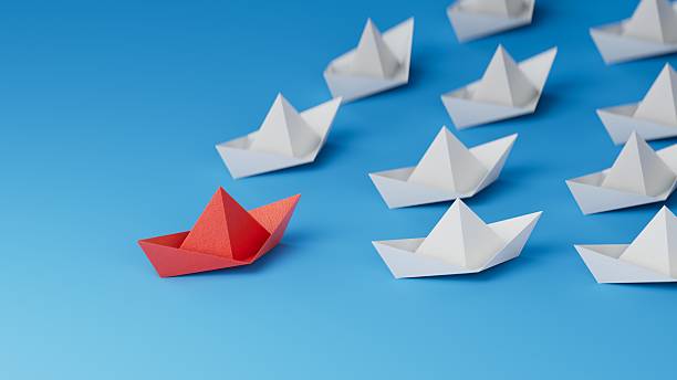 istock Leadership concept. Red leader paper ship leading among white on blue background. copy space.3D rendering on blue background. 2242488420