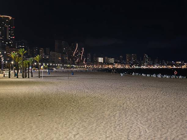 istock serene waterfront scene at night, quiet shoreline with illuminated skyline and peaceful night 2242489586