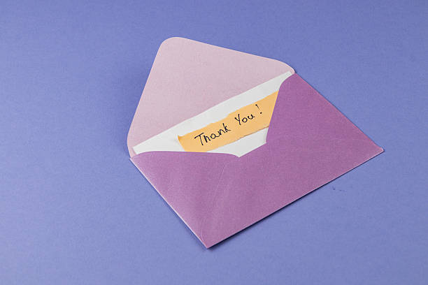 istock Colorful envelope with a thank you note on a purple background 2242490724