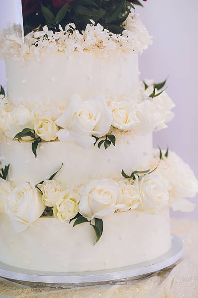 istock Beautiful white wedding cake decorated with flowers close up 2242493830