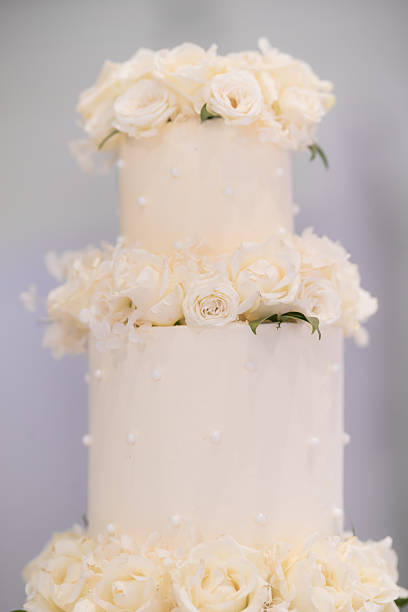 istock Beautiful white wedding cake decorated with flowers close up 2242493846