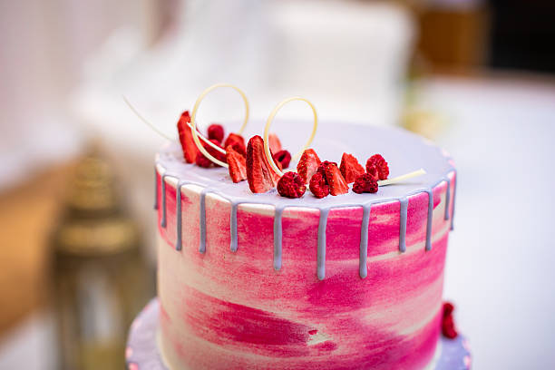 Beautiful pink wedding cake decorated with strawberries close up
