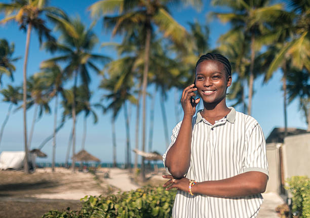 istock Smiling African woman talking on mobile phone at tropical beach 2242496755