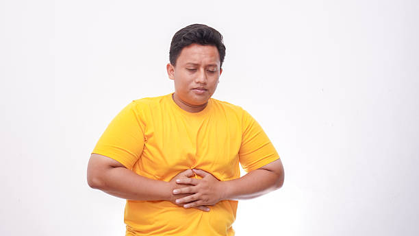 istock Asian fat man got bad stomach ache or gastric pains isolate on white background 2242496984