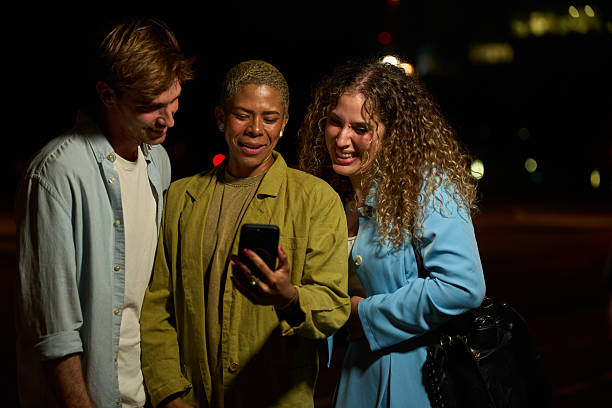 istock Diverse friends sharing content on smartphone at night 2242499094