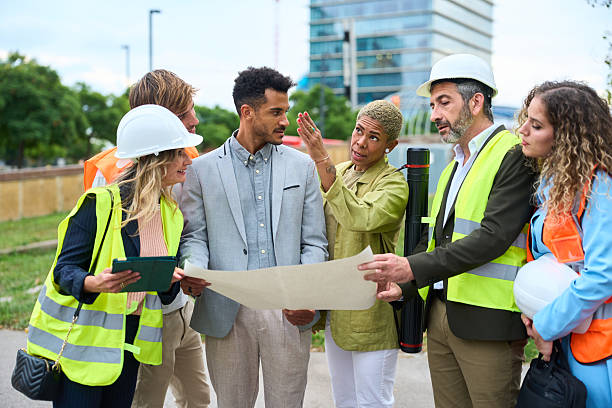 istock Construction team reviewing blueprint and discussing project plan 2242499172