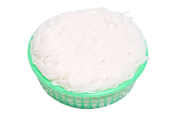 Isolated Thai rice noodles in green basket on white background. fermented rice noodles, rice vermicelli, rice noodles Asian Meal.