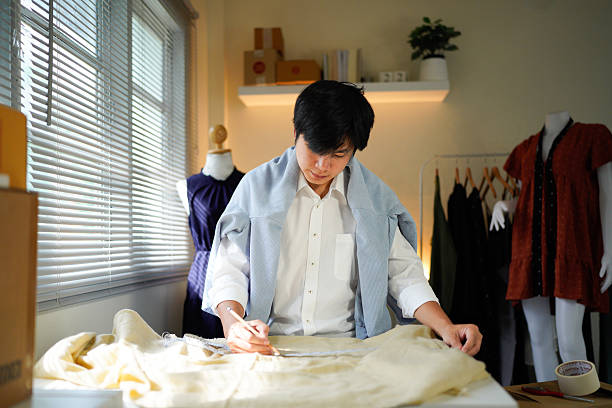 istock A man is doing some work on a piece of fabric as he is taking down measurements and trying his best to be accurate, 2242501909