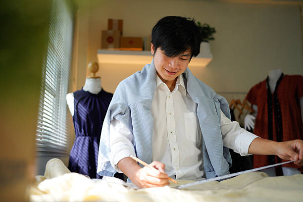 istock A man is doing some work on a piece of fabric as he is taking down measurements and trying his best to be accurate, 2242502048
