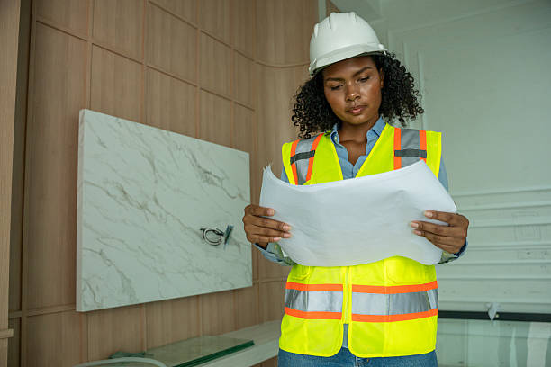 istock Engineers architects wearing safety vests helmets inspect construction site examining building structures discussing project blueprints and tablet construction management, and safety industrial environment. 2242502233