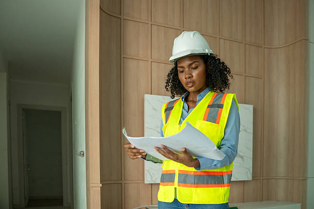 istock Engineers architects wearing safety vests helmets inspect construction site examining building structures discussing project blueprints and tablet construction management, and safety industrial environment. 2242502234