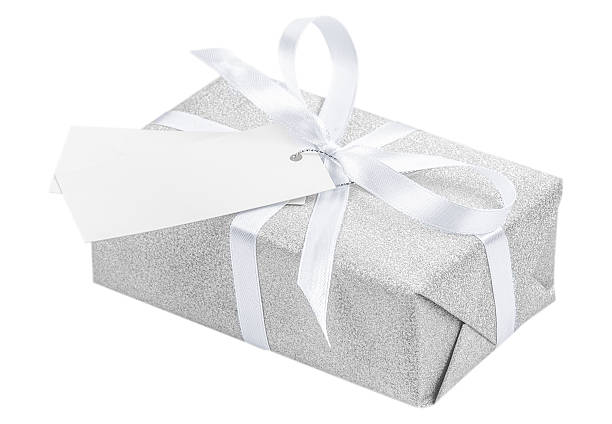 istock Elegant silver gift box wrapped with a white satin ribbon and blank tag, isolated on white background, symbolizing luxury, celebration, and minimalist holiday style 2242505976