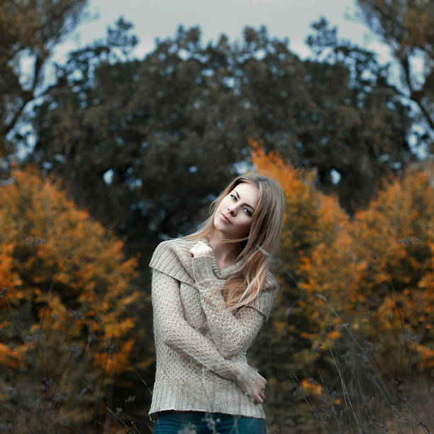 Girl in a sweater standing in a field