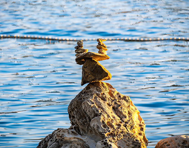 Rab, Croatia - 25 August 2025: Balanced rocks forming a sculpture by the water's edge.