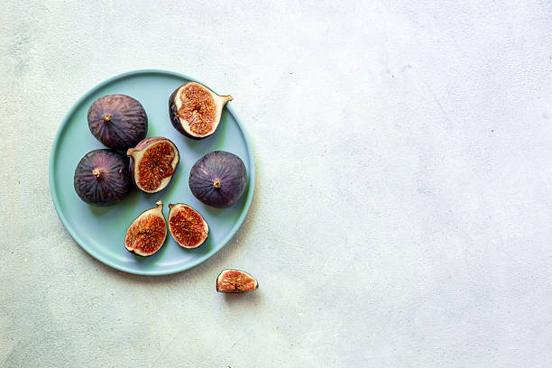 istock Fresh ripe figs on a plate top view on a gray background 2242507950
