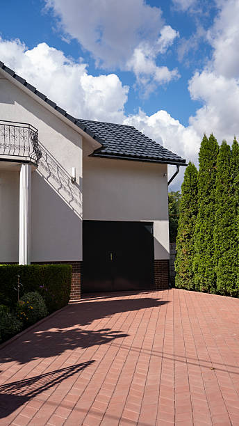 istock A modern residential home with a sleek garage, surrounded by lush greenery on a sunny day. 2242508270