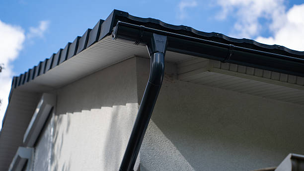 istock Close-up of a modern roof's eaves and gutter system on a home, showcasing sleek lines against a bright blue sky. 2242508450
