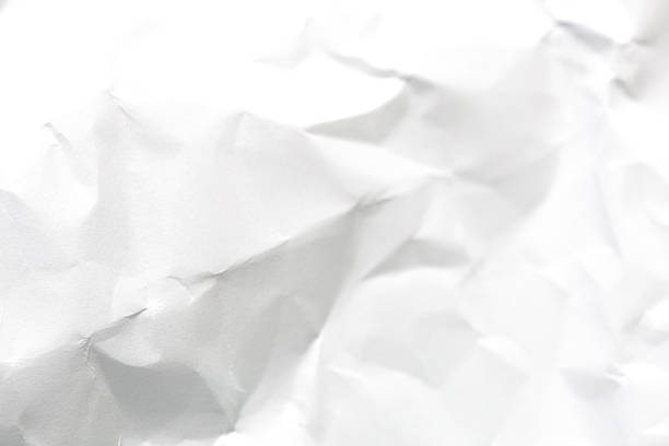 A dramatic collection of crumpled paper sheets in monochrome, highlighting the stark interplay of deep shadows, bright highlights, and intricate abstract textures.