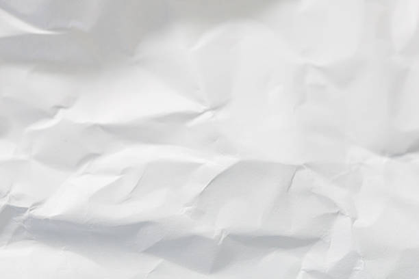 A dramatic collection of crumpled paper sheets in monochrome, highlighting the stark interplay of deep shadows, bright highlights, and intricate abstract textures.