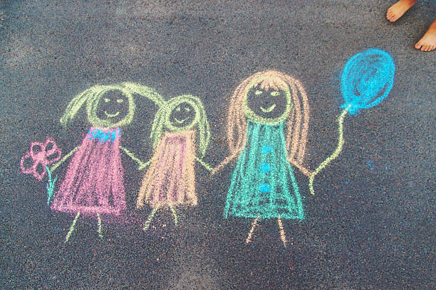 Children draw with chalk on the asphalt. Selective focus. kid.
