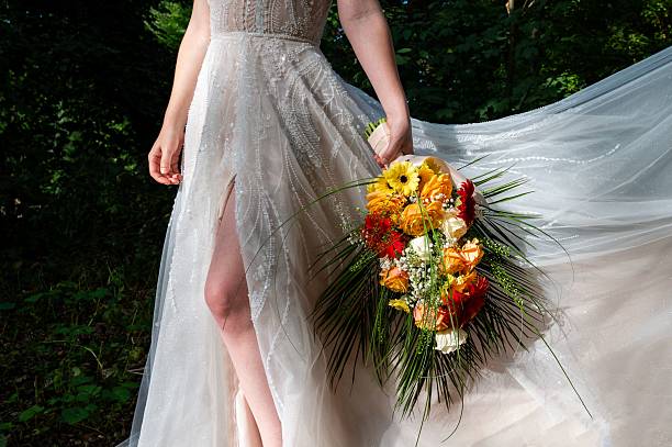 istock Bride with a vibrant bouquet in a sunlit garden. 2242512112