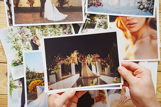 istock Men's hands put on the table and show wedding photos. 2242515845
