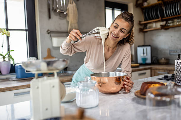 istock Happy Home Baker Whisking Batter in Copper Bowl in Bright Modern Kitchen 2242518073
