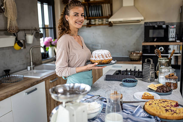 istock Smiling Woman Holds dusted Bundt Cake In Modern Kitchen During Home Baking Session 2242518838