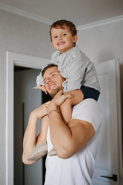 istock Father Holding Happy Toddler On Shoulders 2242519428