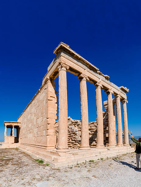 The iconic erechtheion temple with its ionic columns and caryatids porch on the acropolis of athens under a deep blue sky, Greece