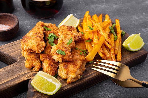 istock British Traditional Fish and chips with lime, sauce and cold beer on grey background close up 2242519649