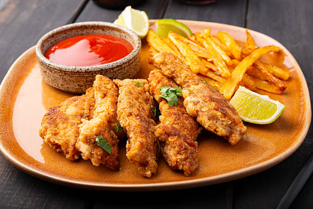istock British Traditional Fish and chips with lime, sauce and cold beer on black background close up 2242519781