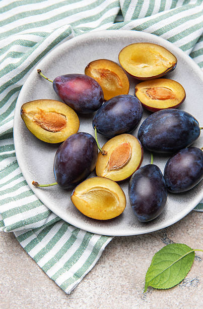 istock Fresh ripe plums with halves on plate for healthy eating 2242522358