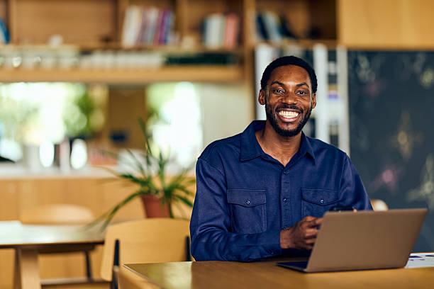 istock African-American Man Smiling While Using Laptop At A Cafe 2242525120