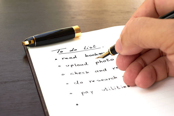 istock Planning daily tasks with a pen on notebook in a cozy workspace 2242525424