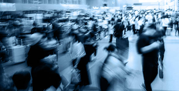 Crowd of people walking indoors walkway, blurred totion