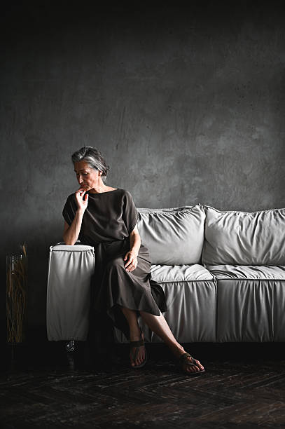Senior woman relaxing on sofa feeling peace and calm