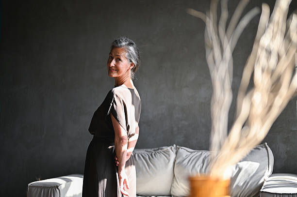 istock Senior woman smiling looking back in home 2242537052