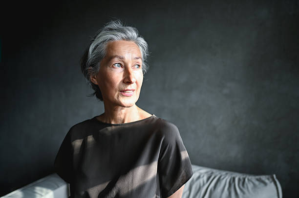 istock Senior woman looking away, sunlight falling on her face 2242537098