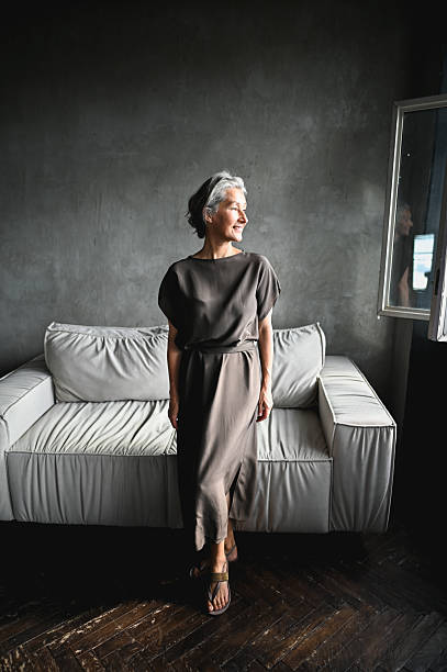 istock Senior woman smiling looking away in modern interior 2242537137