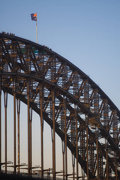 Fearless bridge-climbing tourists reach the traditional Australian flag sitting atop Sydney's iconic Harbour Bridge.