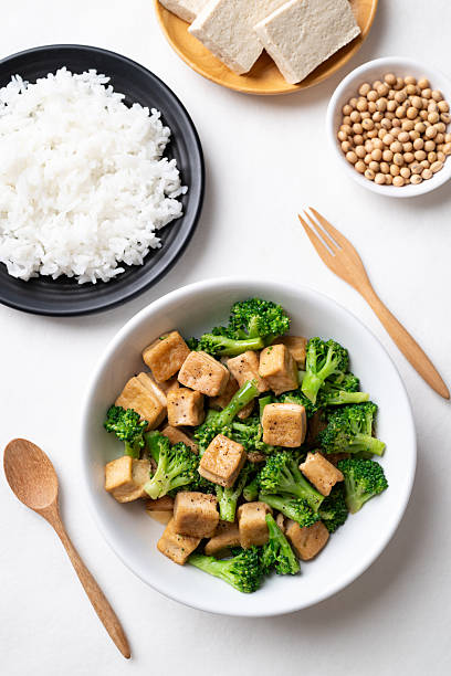 Stir fried tofu and broccoli with soy sauce eating with cooked rice, Asian vegan food
