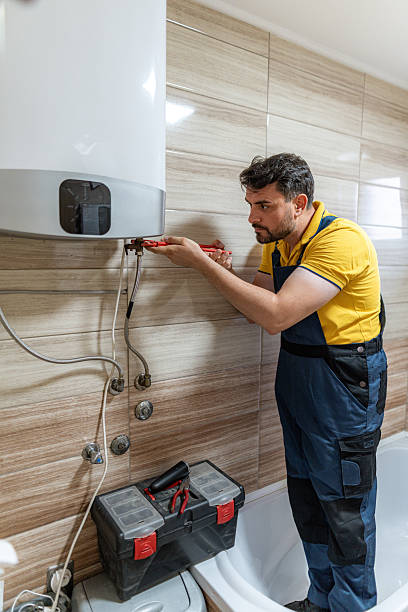 istock Plumber repairs water heater in modern bathroom setting during daytime 2242546755