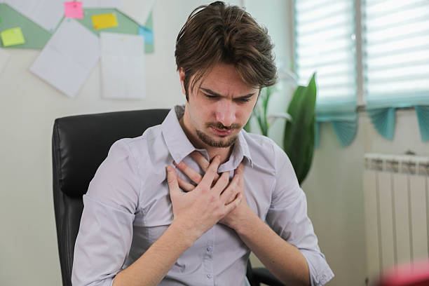 istock Young Man Sitting at Office Desk Feeling Chest Pain While Working on Laptop 2242546791