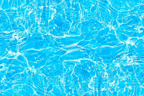 istock Blue water with ripples on the surface. Defocus blurred transparent blue colored clear calm water surface texture with splashes and bubbles. Water waves with shining pattern texture background. 2242548976